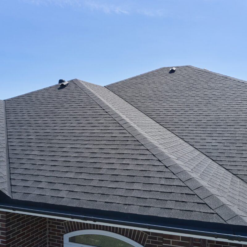 Gray shingle roof under clear blue sky